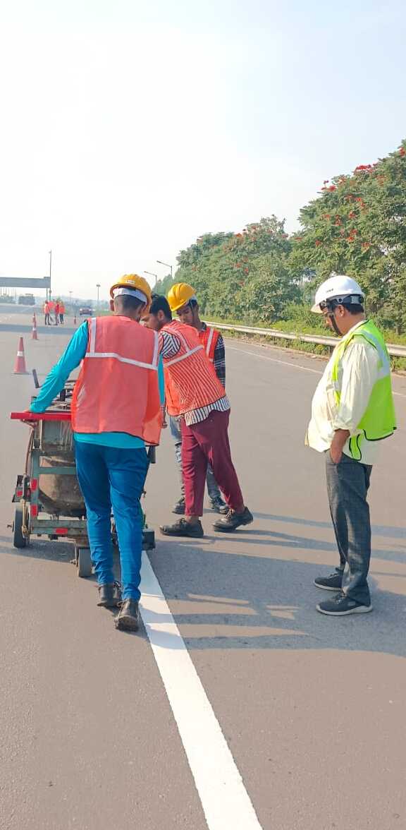 team of infrastructure workers in high visibility gear on a highway